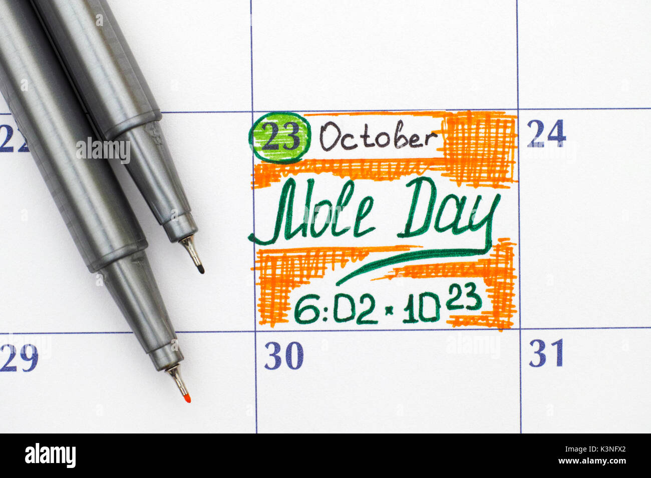 Reminder Mole Day in calendar with two pens. Mole Day is an unofficial
