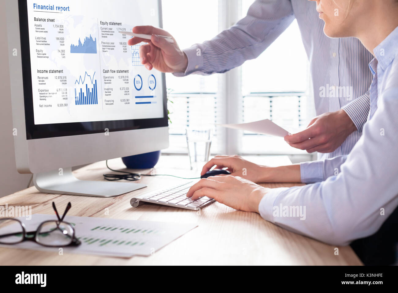 Team of consulting auditors auditing the financial report data of the company (balance sheet, income statement) on computer screen with business chart Stock Photo