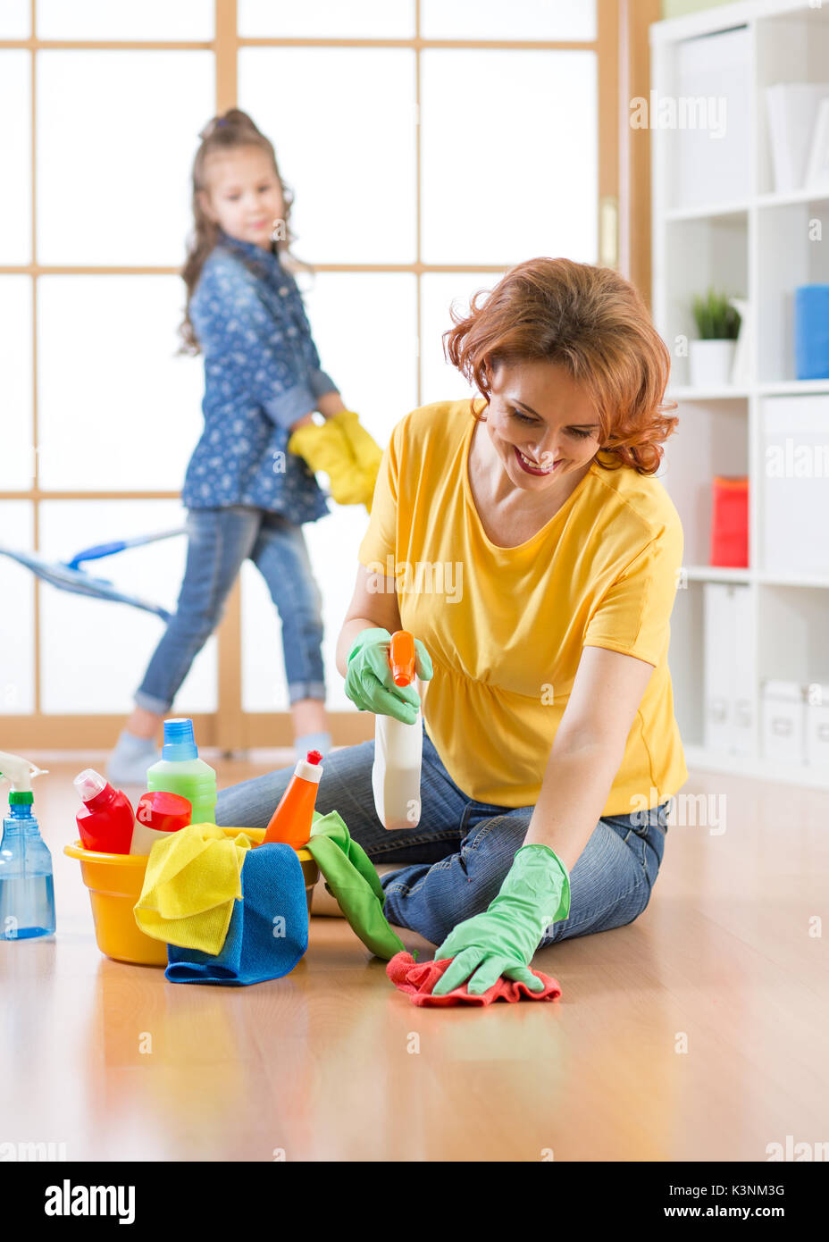 Happy family cleans the room. Mother and her daughter do the cleaning in the house. Stock Photo