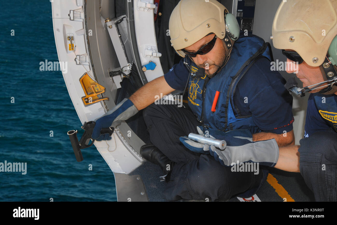 Australian Maritime Safety Authority at work loading a flare gun, in a Dornier 235 aircraft. Stock Photo