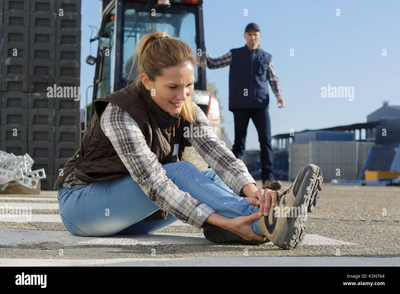 female builder putting working shoes on Stock Photo