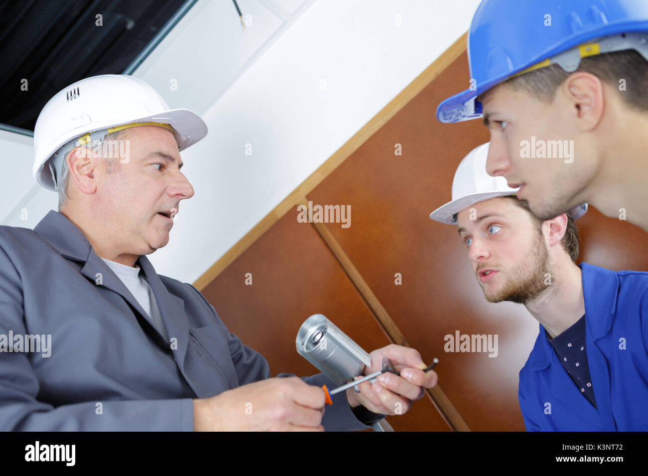 young technicians learning to installing camera in building corner Stock Photo