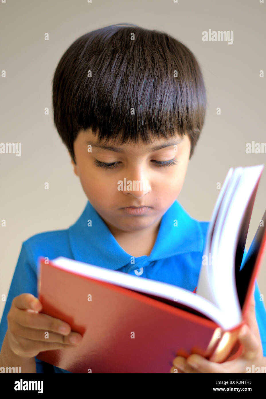 Kid reading book. Boy holding a book. Kid looking into the book. Stock Photo