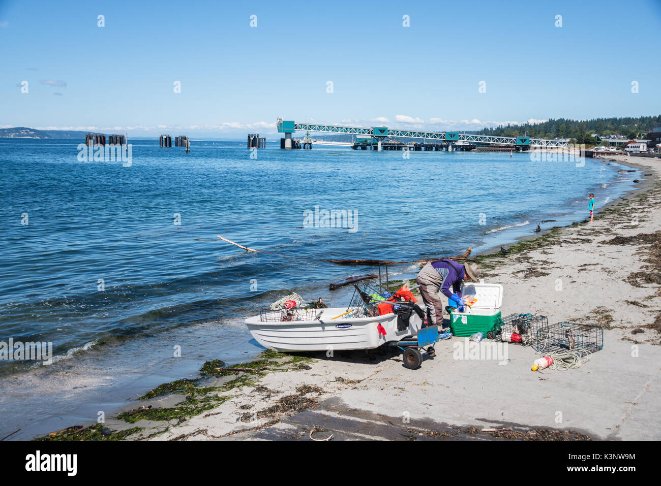 Fisherman Preparing his Dingy on Beach to Go Crabbing Stock Photo