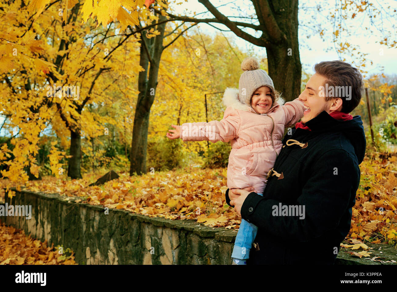 A father walks with a child daughter in the park in the autumn Stock ...