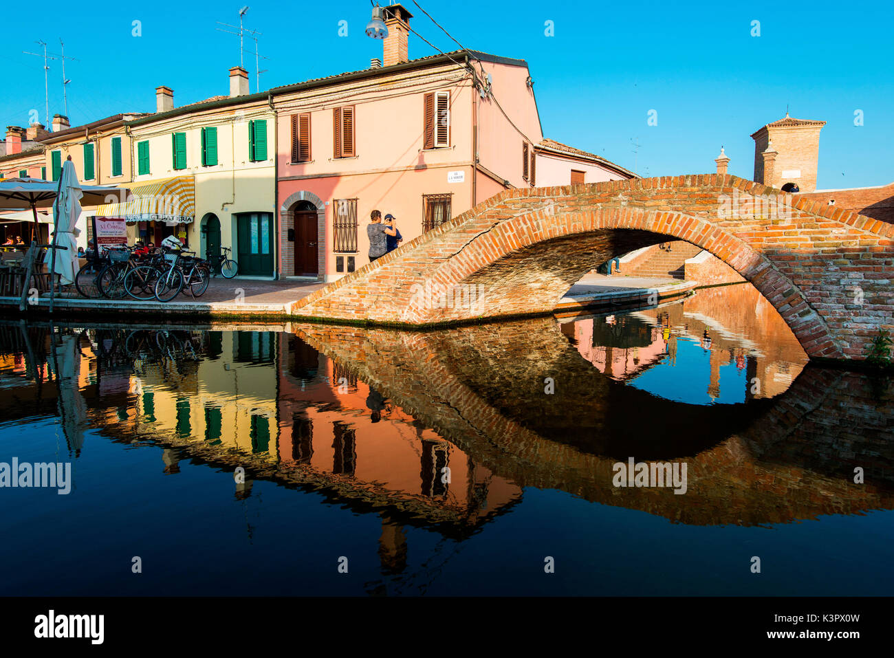 Comacchio, Ferrara, Emilia Romagna, Italy, Europe. An old bridge reflexed in the canal. Stock Photo