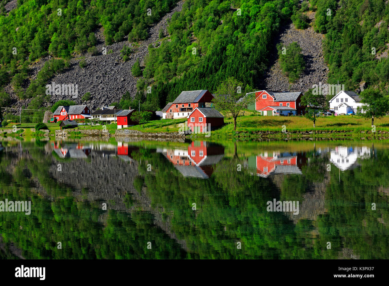 Perfect reflection of some typical norvegia houses into a lake in late spring, Odda, Hardaland, Norway Stock Photo