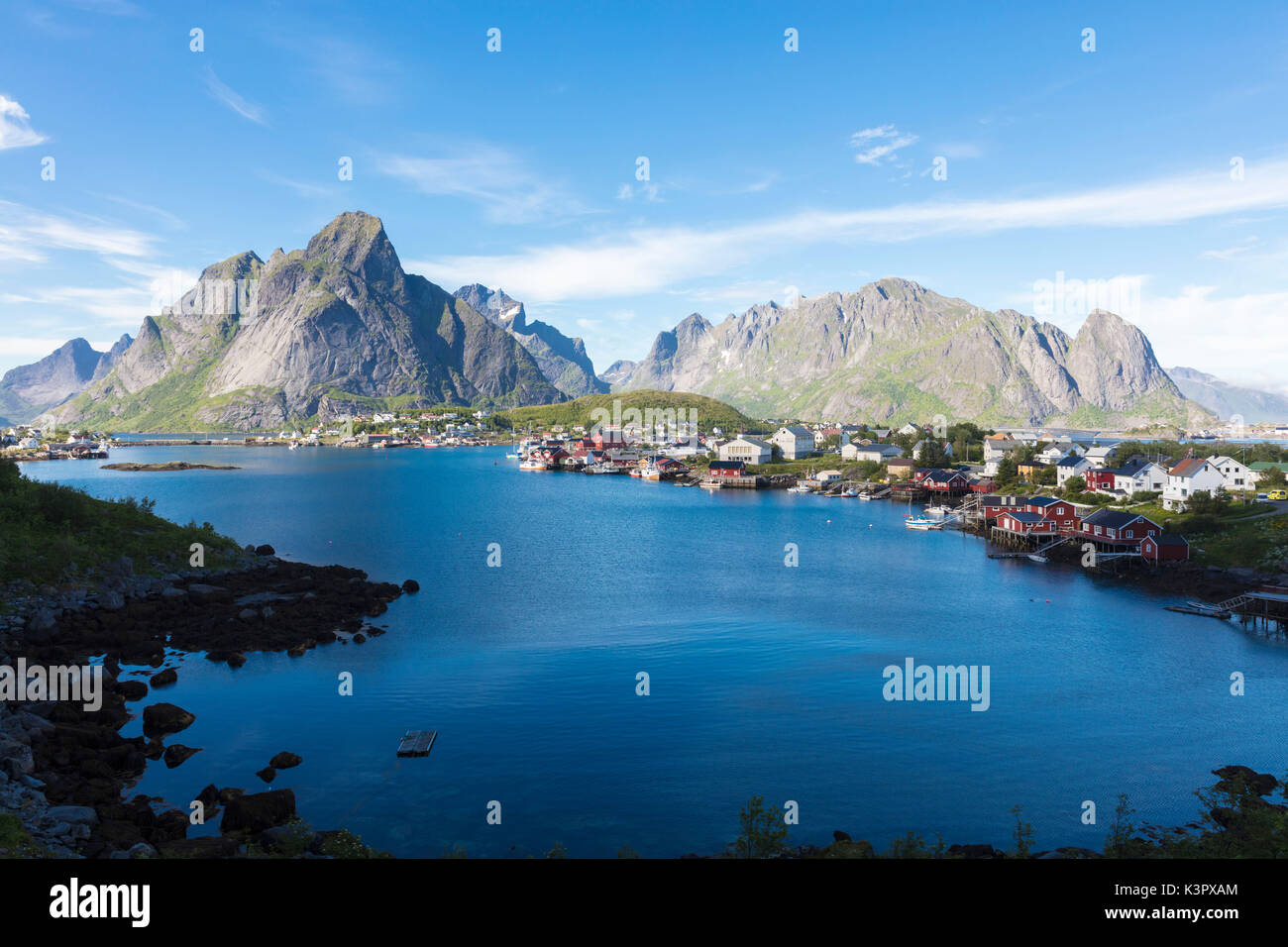 The blue sea frames the fishing village and the rocky peaks at dusk Reine Moskenes Lofoten Islands Norway Europe Stock Photo