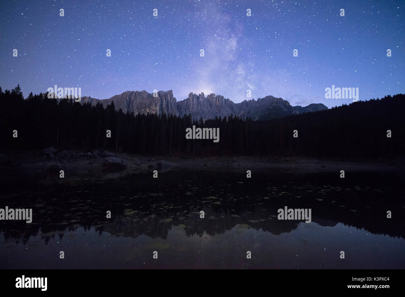 Stars on the peaks of Latemar mountain range reflected in Lake Carezza Ega Valley Province of Bolzano South Tyrol Italy Europe Stock Photo