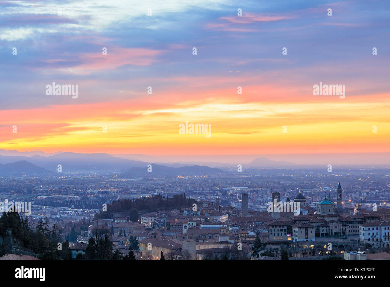 View of the medieval old town called Città Alta on hilltop framed by the fiery orange sky at dawn Bergamo Lombardy Italy Europe Stock Photo