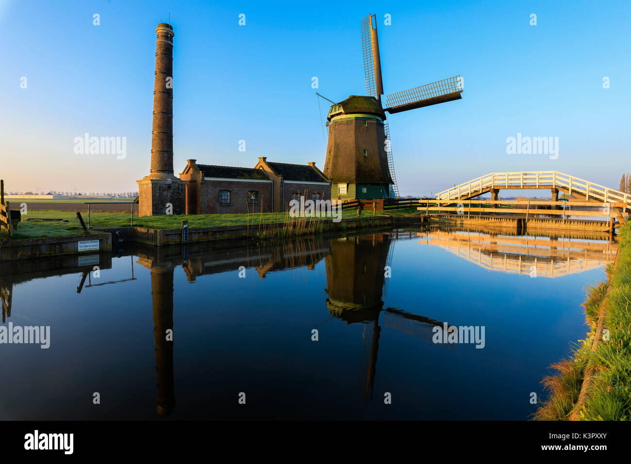 Typical windmill reflected in the canal at dawn Berkmeer municipality of Koggenland North Holland The Netherlands Europe Stock Photo
