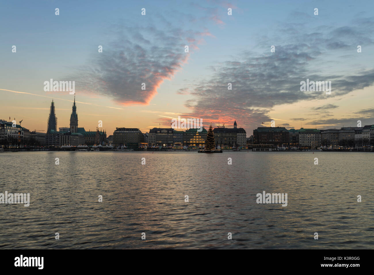 The artificial Inner Alster Lake frames the old buildings and palace of the city center at dusk Hamburg Germany Euope Stock Photo