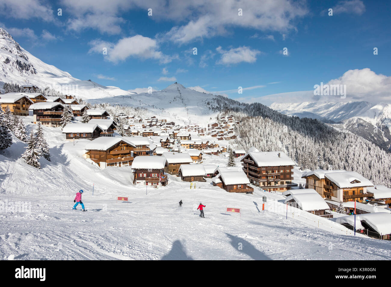 Skiers on the ski slopes frame the typical alpine village Bettmeralp district of Raron canton of Valais Switzerland Europe Stock Photo