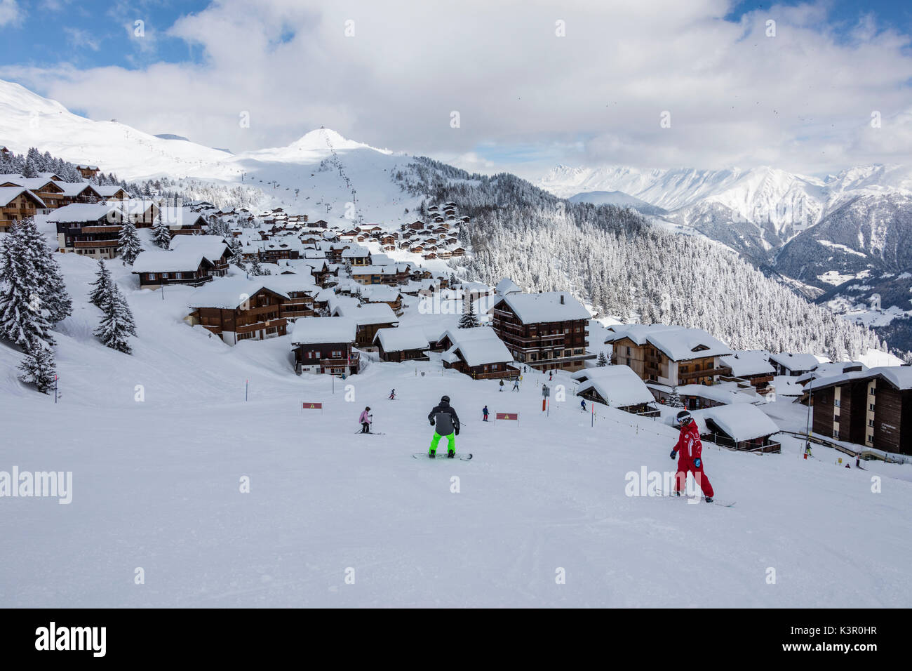 Snowboarders on ski slopes frames the typical alpine village Bettmeralp district of Raron canton of Valais Switzerland Europe Stock Photo