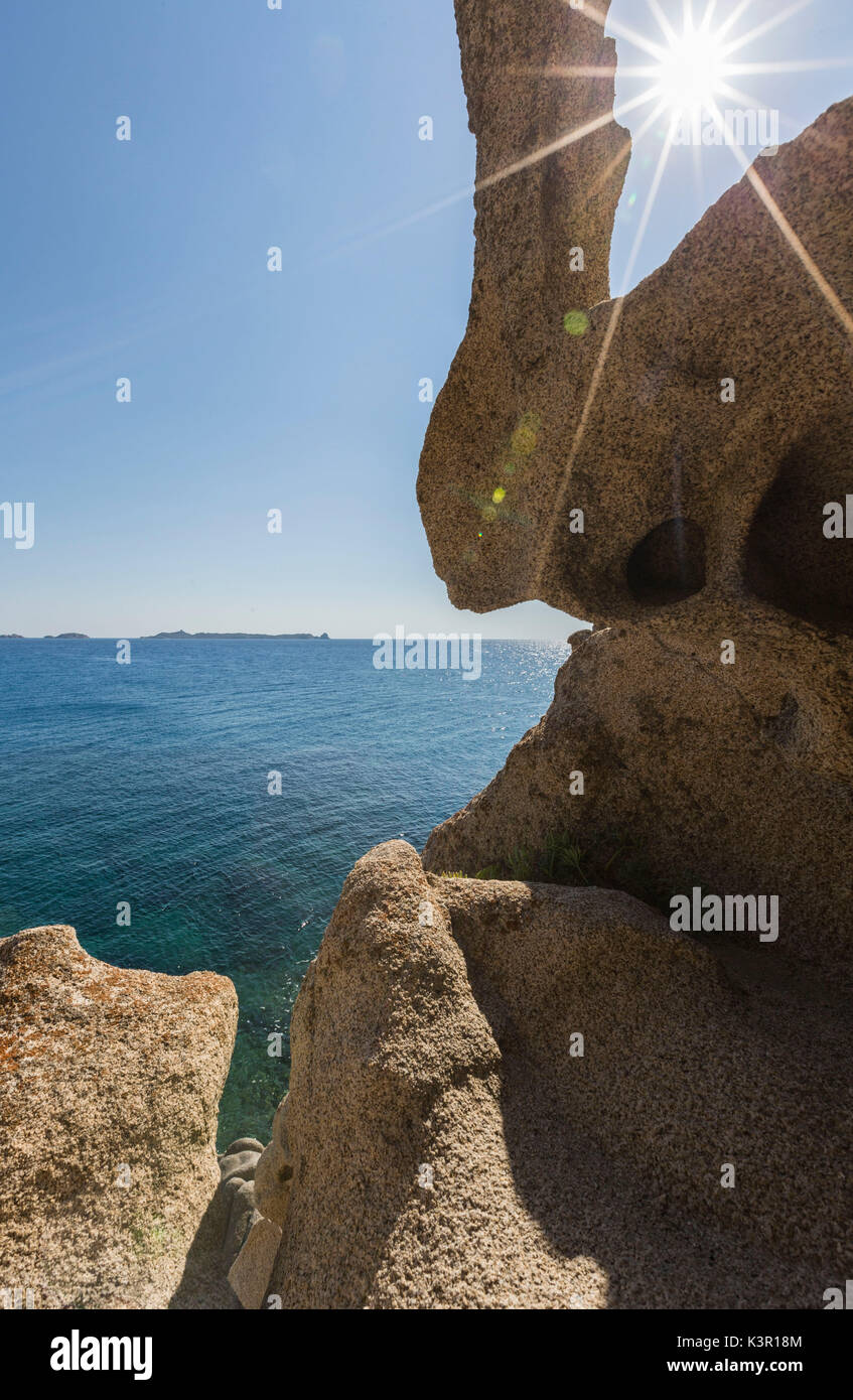 Sunbeams are reflected on the blue sea framed by rocks of the cliffs Punta Molentis Villasimius Cagliari Sardinia Italy Europe Stock Photo
