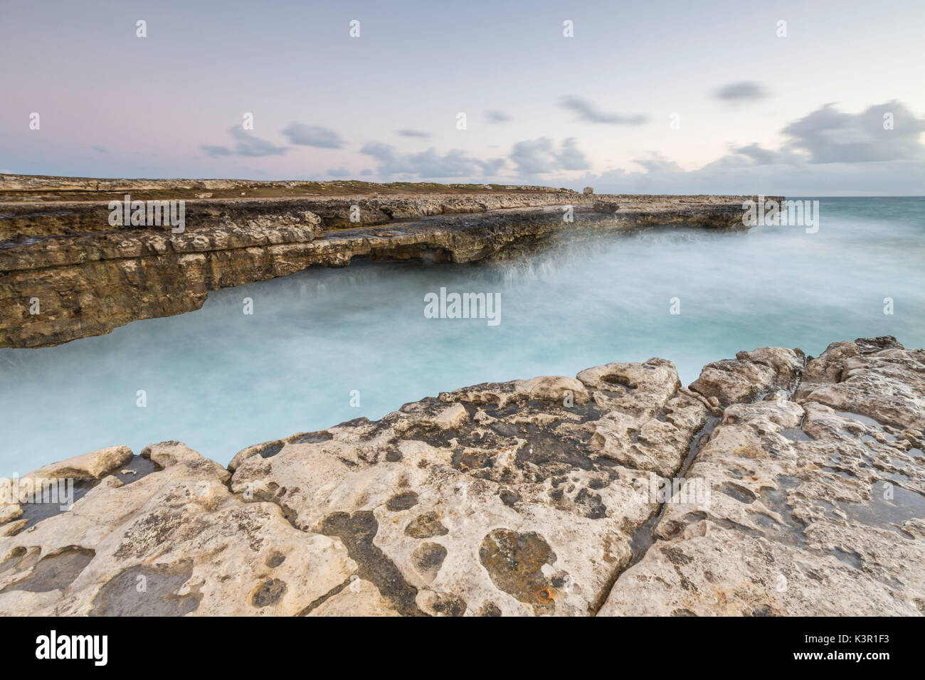 Waves crashing on natural arches carved by the sea at Devil's Bridge Caribbean Antigua and Barbuda Leeward Islands West Indies Stock Photo