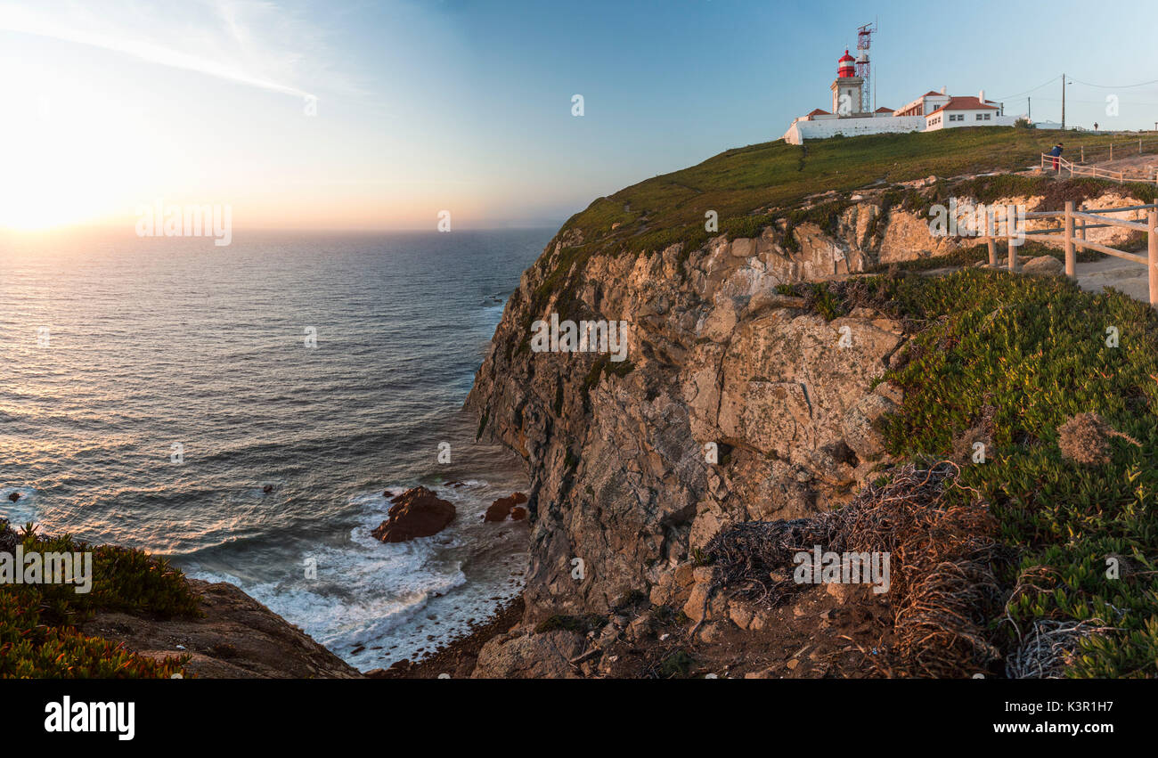 The colors of the sunset on the cape and lighthouse of Cabo da Roca overlooking the Atlantic Ocean Sintra Portugal Europe Stock Photo