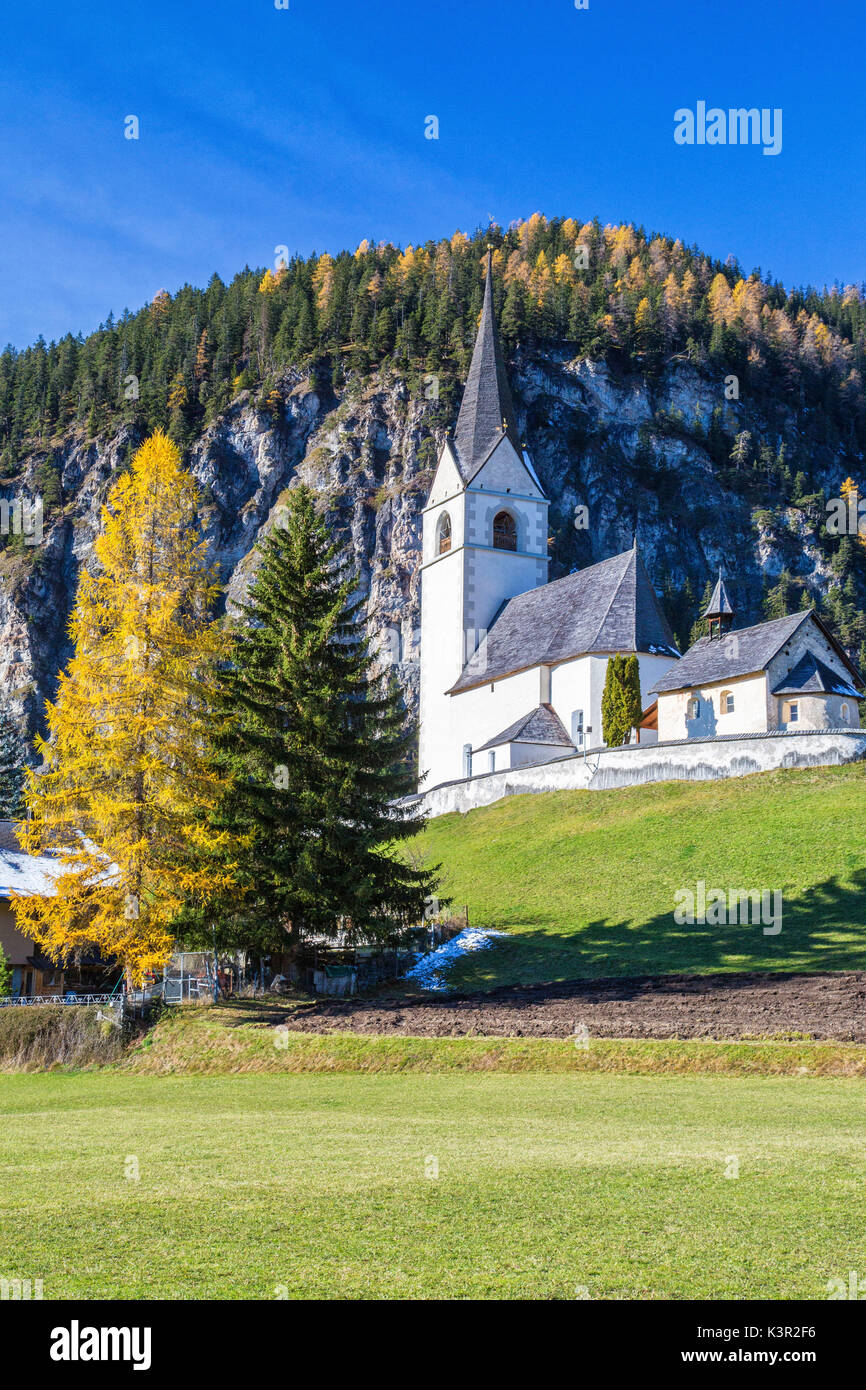 The church of Schmitten surrounded by colorful woods Albula District Canton of Graubünden Switzerland Europe Stock Photo