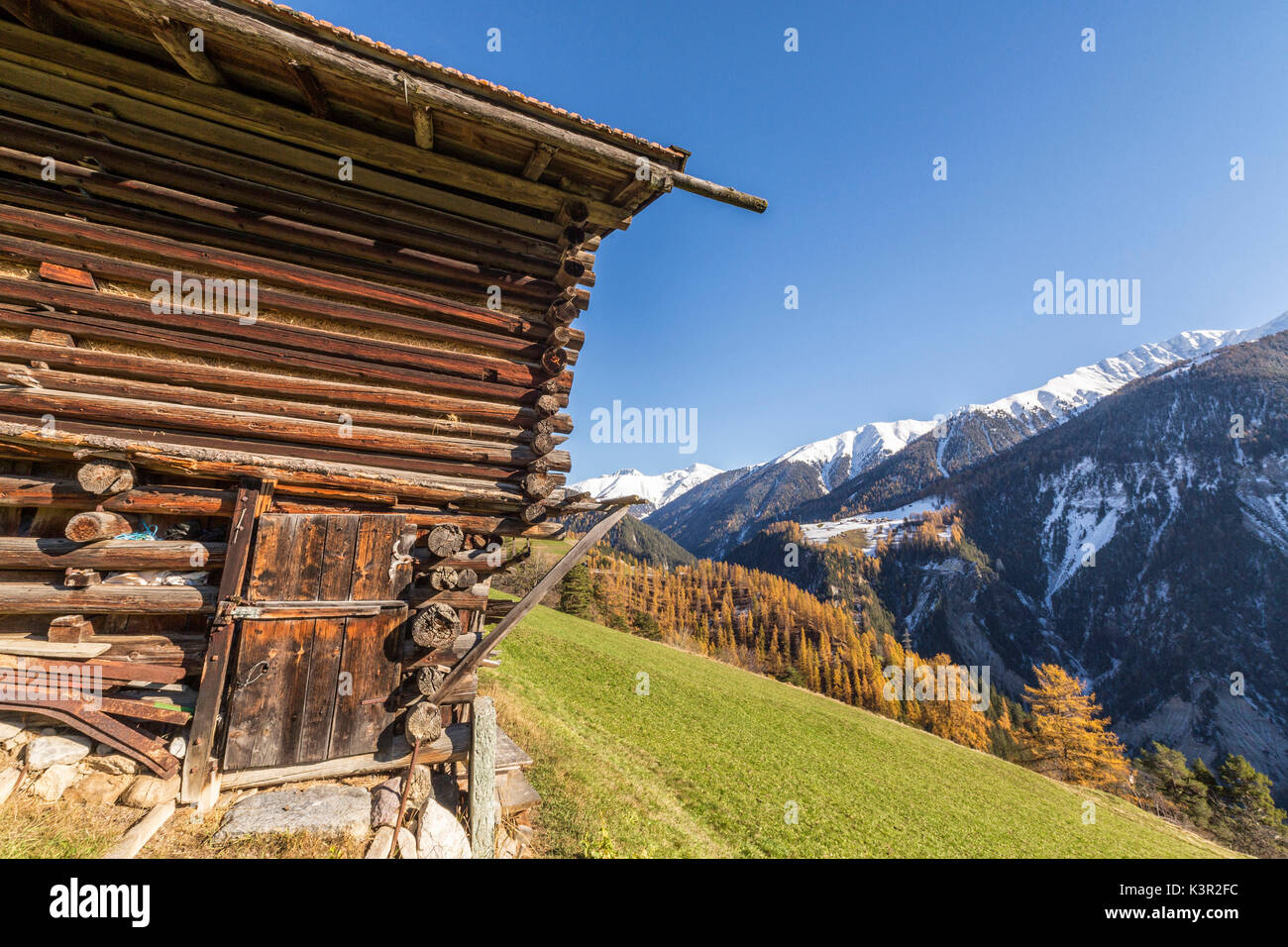 Wooden cabin surrounded by colorful woods and snowy peaks Schmitten Albula District Canton of Graubünden Switzerland Europe Stock Photo