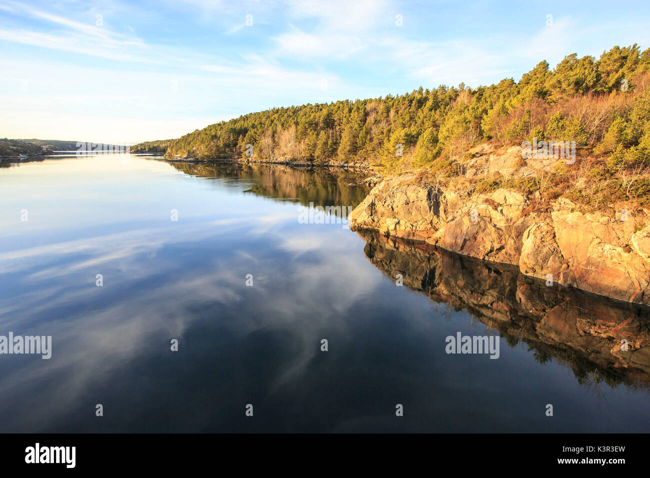 Woods are reflected in the calm waters Hitra Island Trøndelag Norway Europe Stock Photo