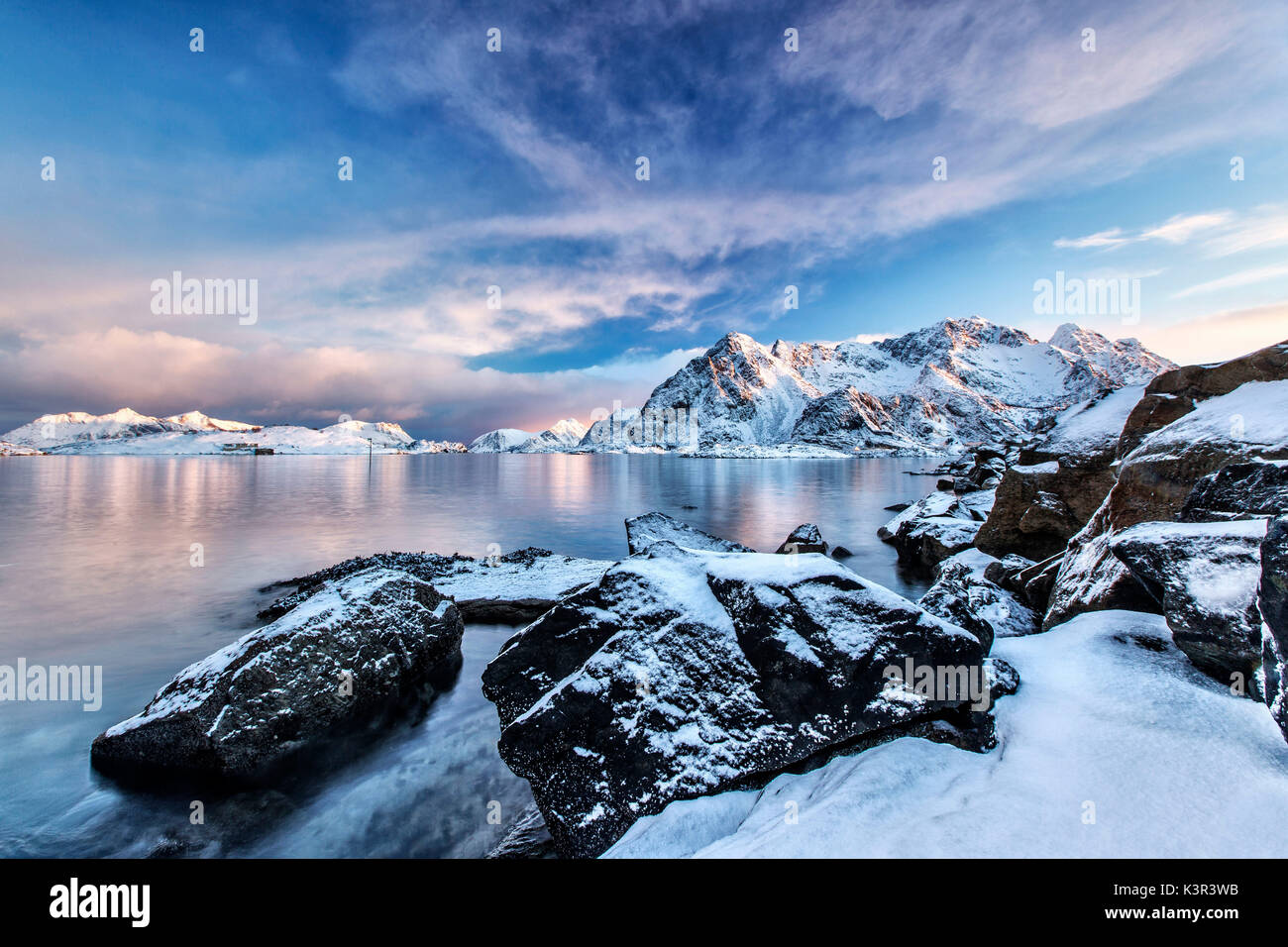 The colors of dawn light up the sea in Henningsvaer fjord. Lofoten Islands. Norway. Europe Stock Photo