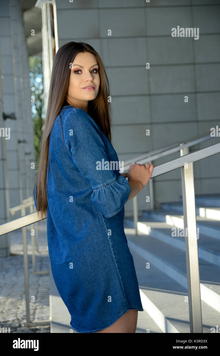 Young female model wearing blue jeans dress. Girl posing in Wroclaw