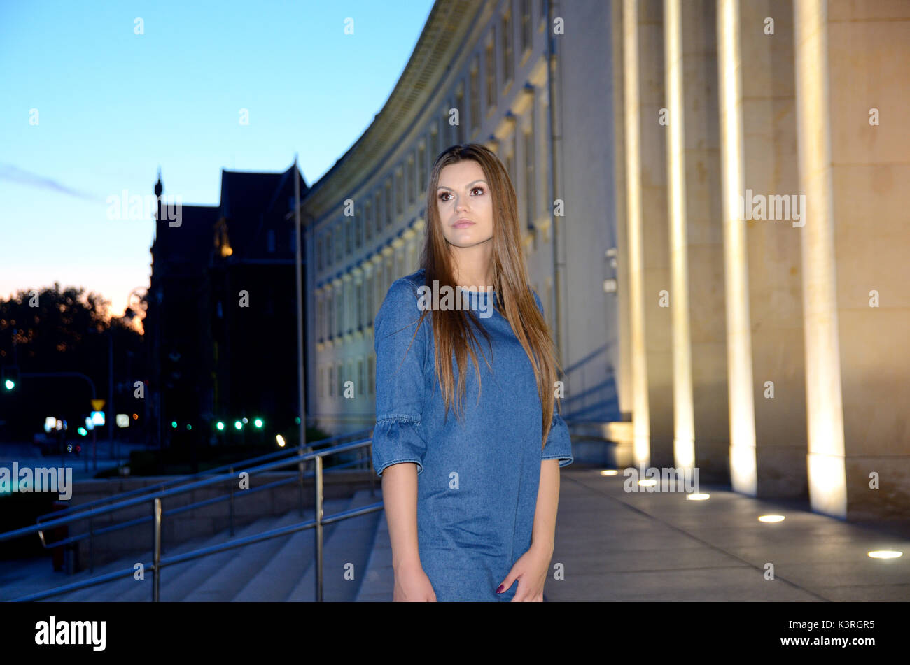 Young female model wearing blue jeans dress. Girl posing in Wroclaw city,  Poland. Photo session in the evening Stock Photo - Alamy