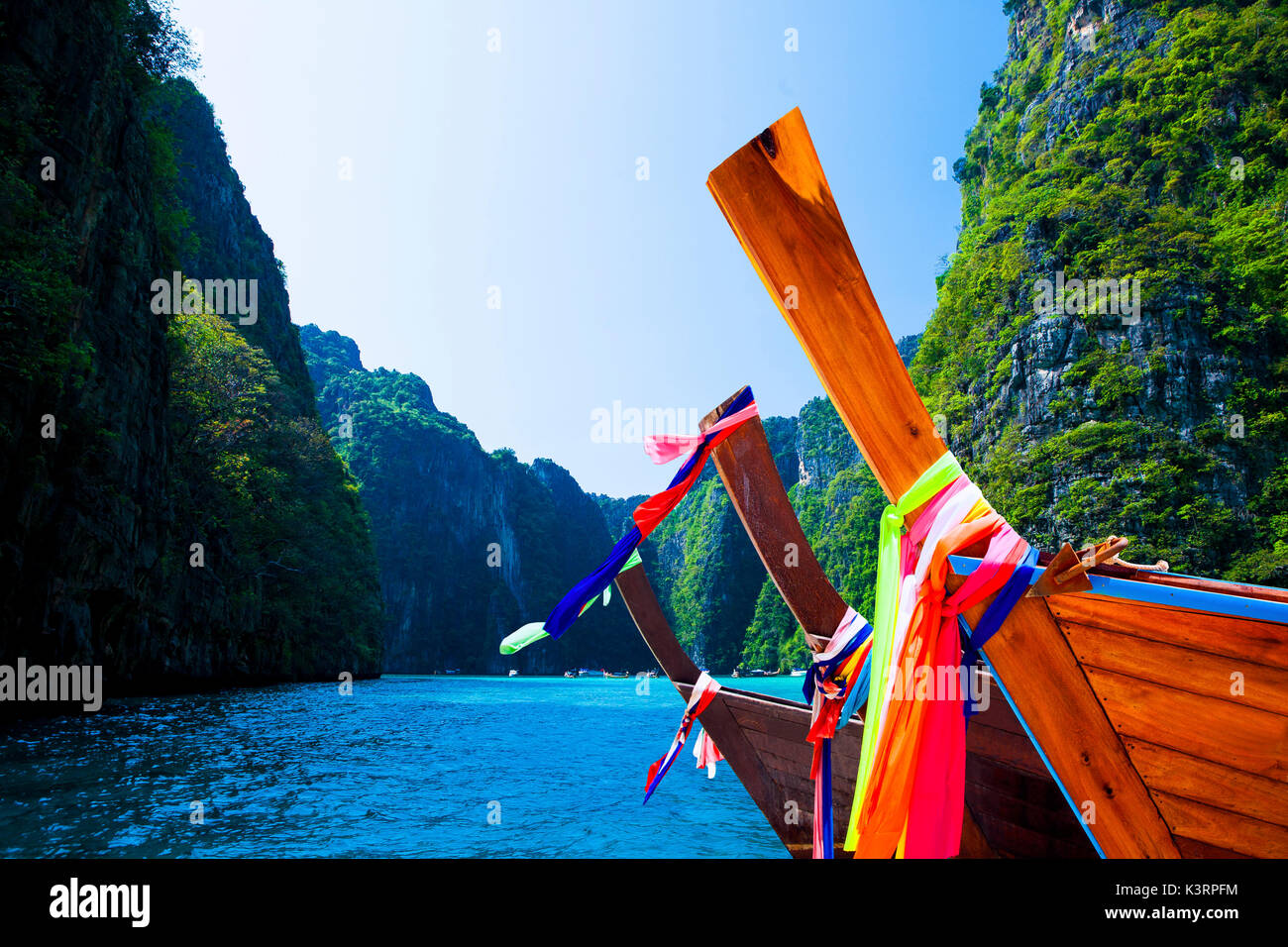 Thailand beach seascape with ring of steep limestone hills and traditional bright longtail boats parking, Maya Bay, Ko Phi Phi Lee island, Phi Phi arc Stock Photo