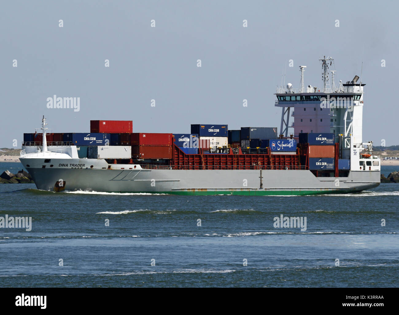 The container ship Dina Trader leaves the port of Rotterdam. Stock Photo