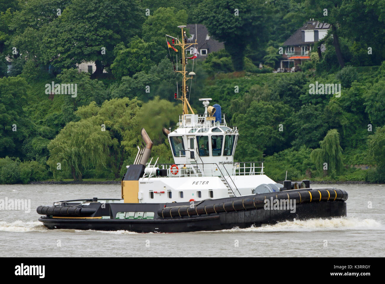 The harbor tug Peter works in the port of Hamburg. Stock Photo