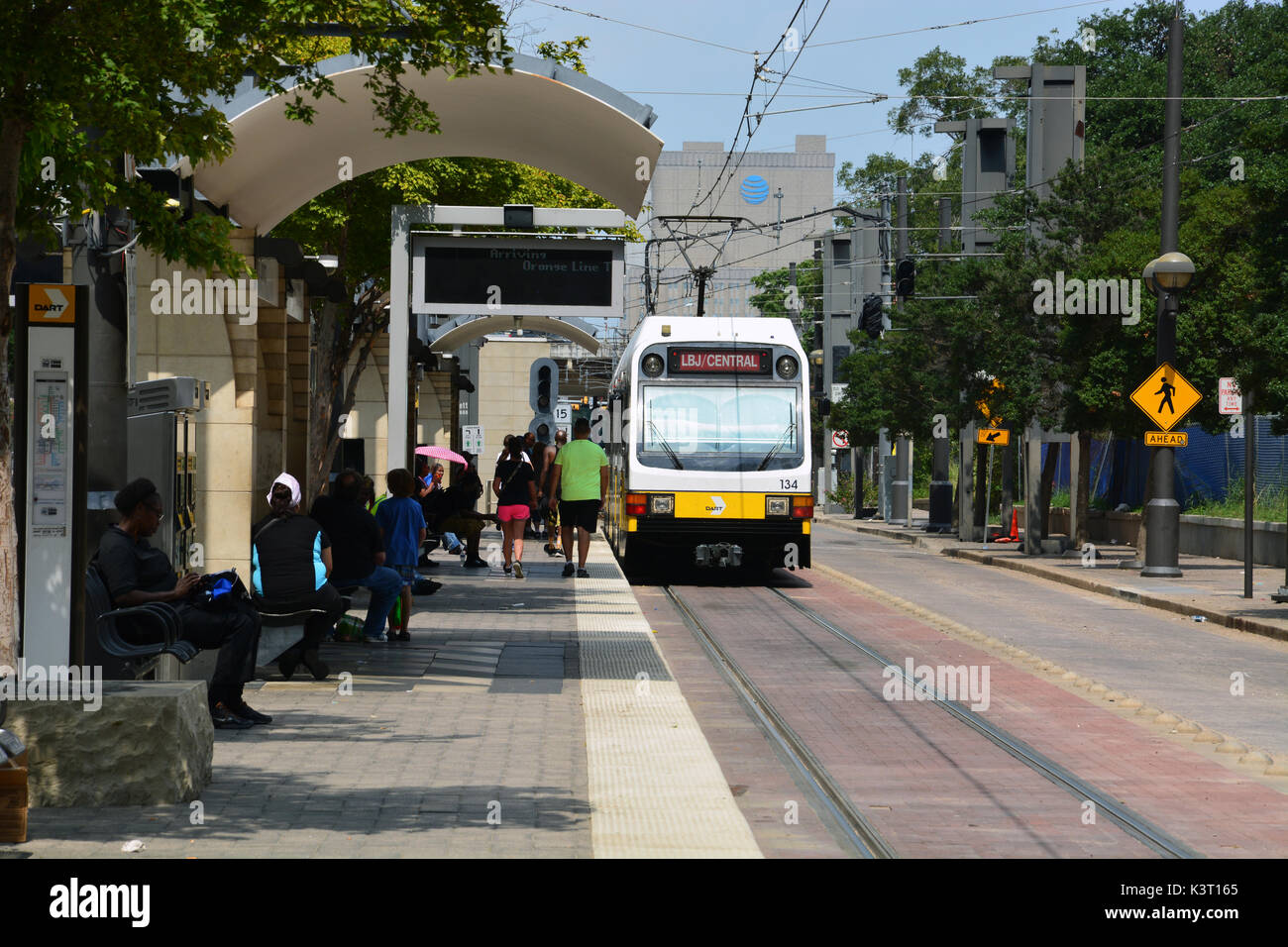Passengers board a red line DART train at the Pearl Arts District in