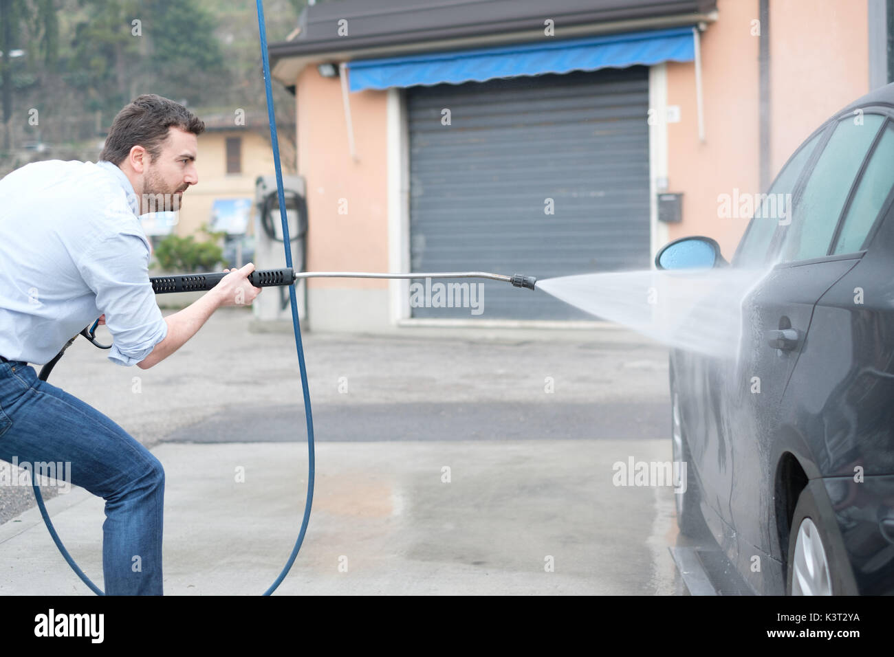 Man washing his car in a selfservice car wash station Stock Photo Alamy