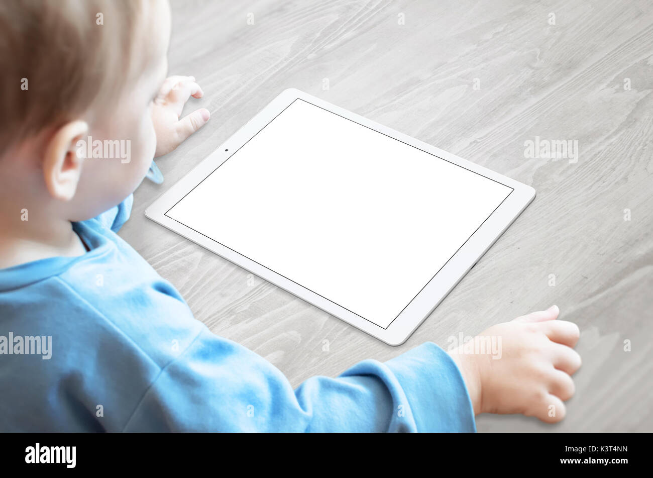 Baby with pacifier watching tablet with isolated screen for mockup. Stock Photo