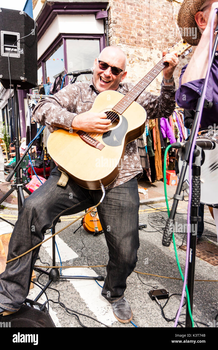 The skiffle group, High Chaparrals playing in the street. Close up of guitarist, playing and posing to the camera, big smile on his face. Stock Photo