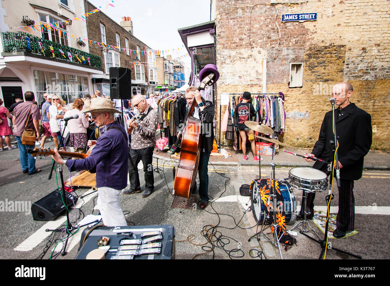 Event, Addington street Fair at Ramsgate, local skiffle group, High Chaparrals, performs in front of people on street junction. Bunting hanging from buildings. Street busy with people. Stock Photo