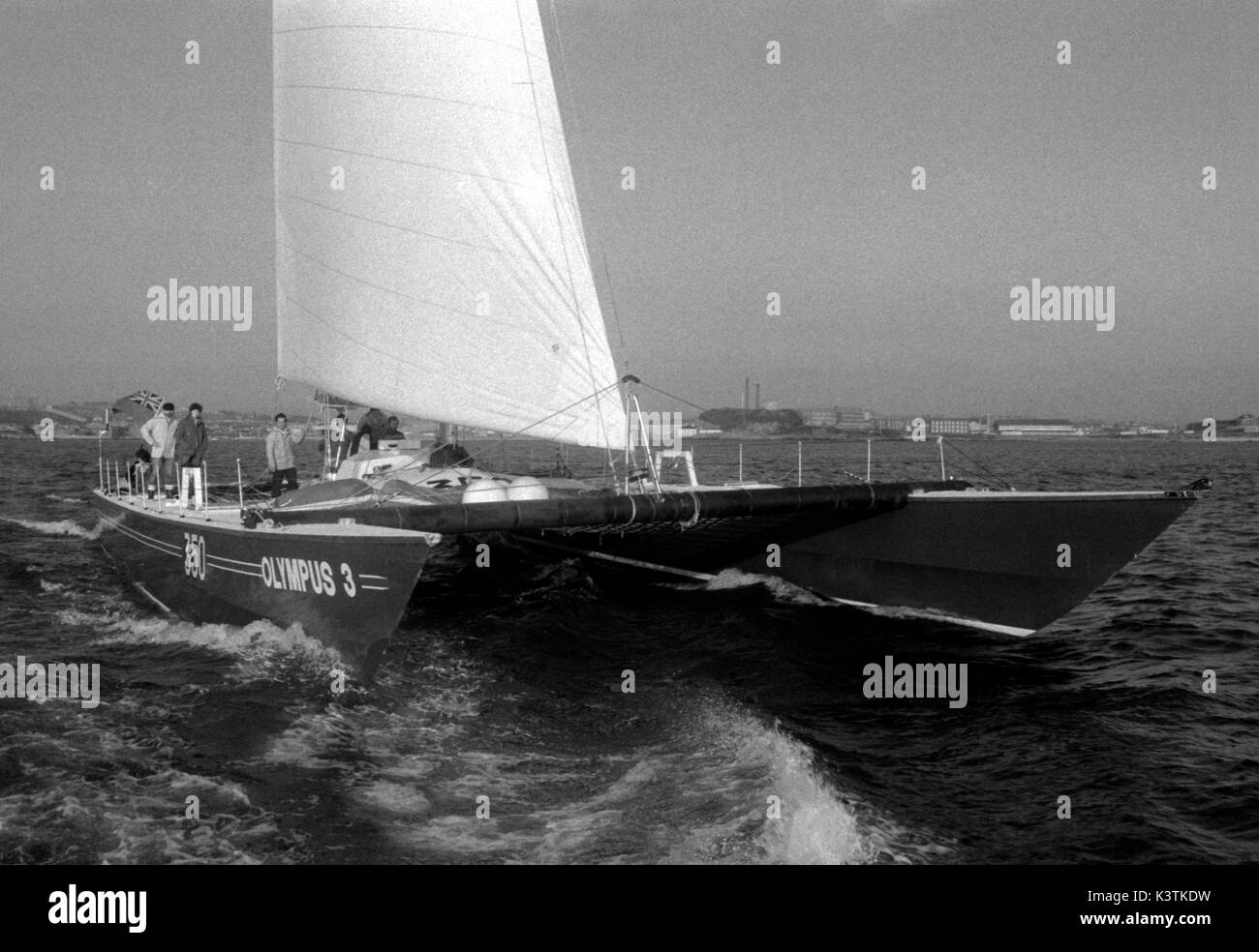 AJAXNETPHOTO. NOVEMBER, 1982. PLYMOUTH, ENGLAND. - ROUTE DU RHUM RACE - OLYMPUS 3 CATAMARAN SKIPPERED BY ROBIN KNOX JOHNSTON HEADS FOR THE START AT ST.MALO, FRANCE. PHOTO:JONATHAN EASTLAND/AJAX REF:821007 53 Stock Photo