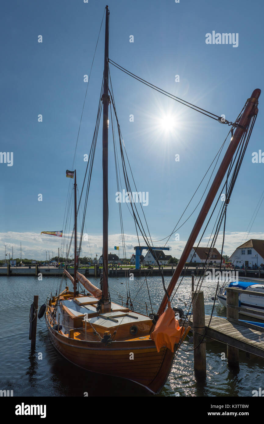 Wooden sailing boat in the port of Neuendorf on the island Hiddensee back-lit by the sun with sunstars, Mecklenburg-West Pomerania, Germany Stock Photo