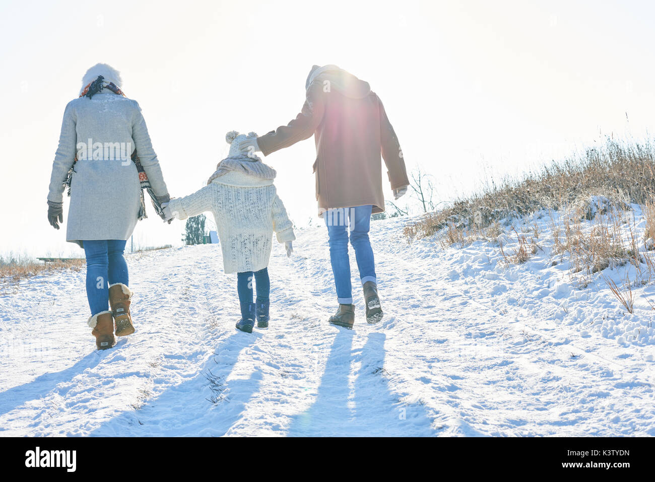 Family takes a winter hiking tour in the snow Stock Photo