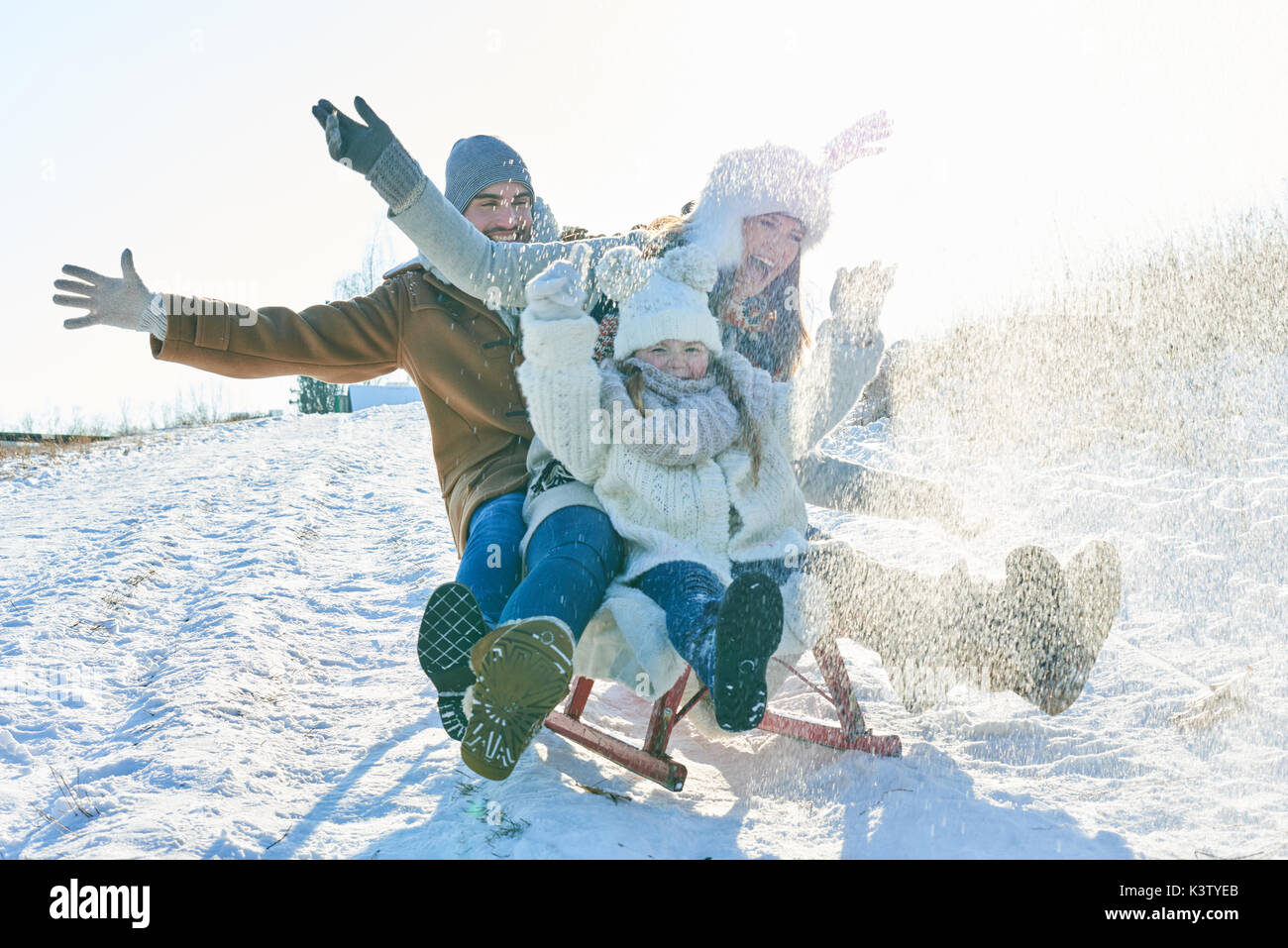 Family driving sled on the snow and having fun in winter Stock Photo