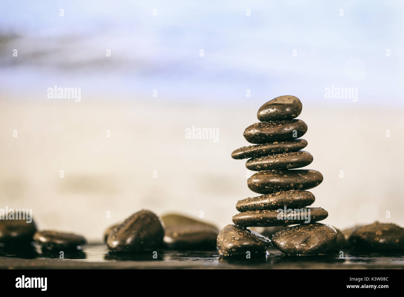 Zen stones stacked on abstract beach background Stock Photo