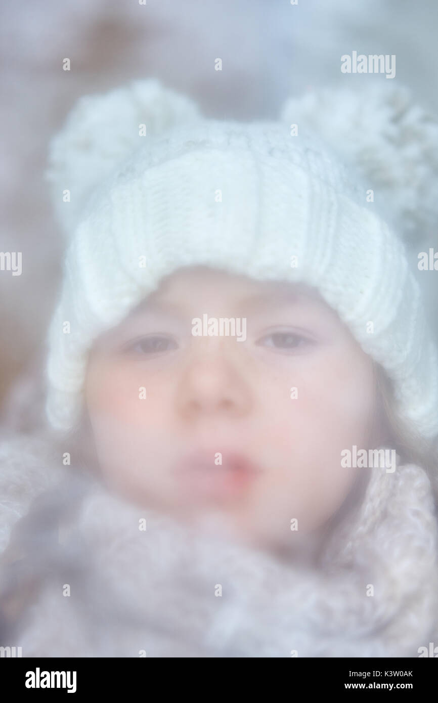 Child looks through steamed up window in winter Stock Photo