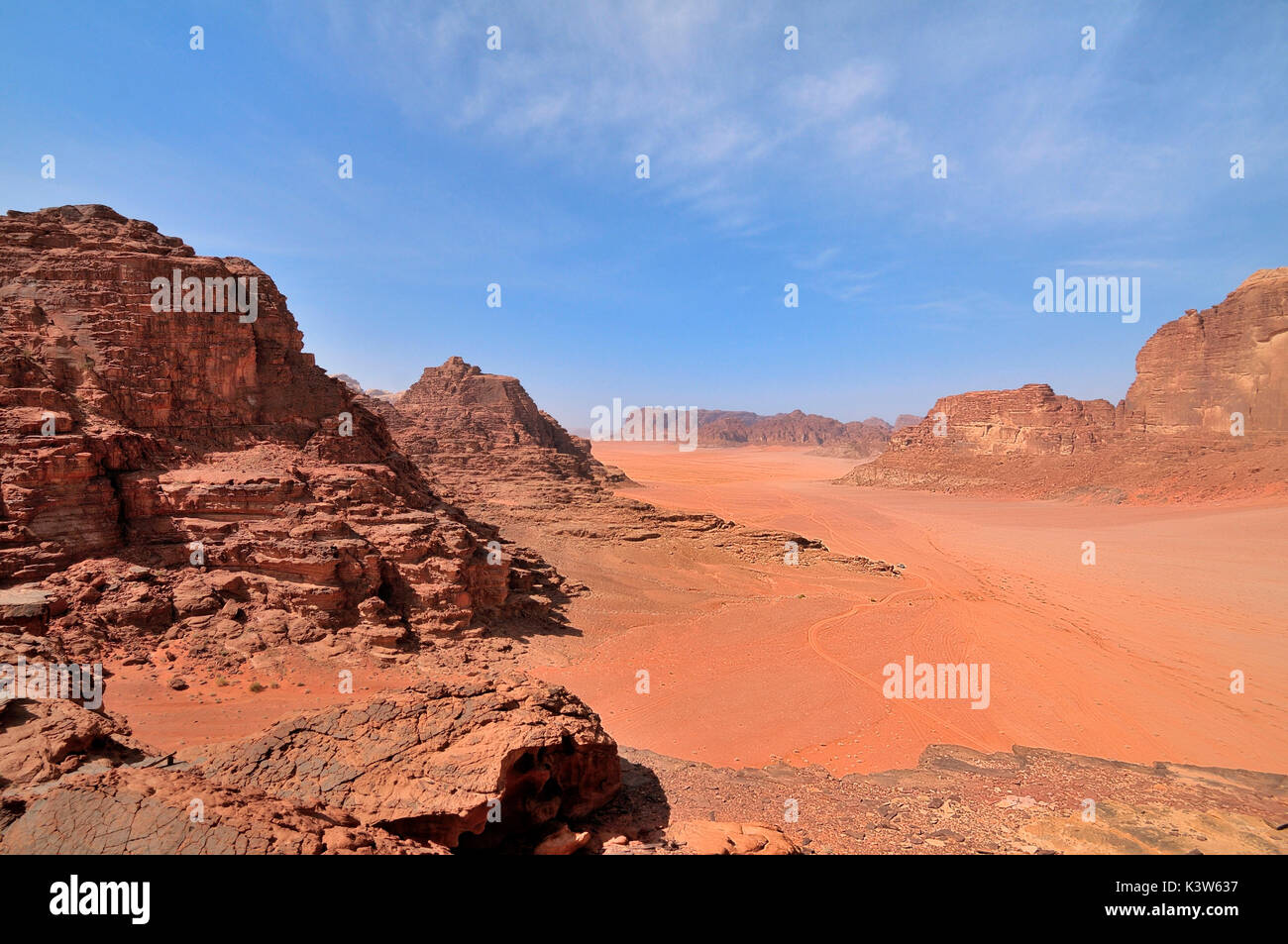 A view from the top of the sunny and arid desert of Wadi Rum; with its red earth in contrast with the blue sky of Jordan Stock Photo