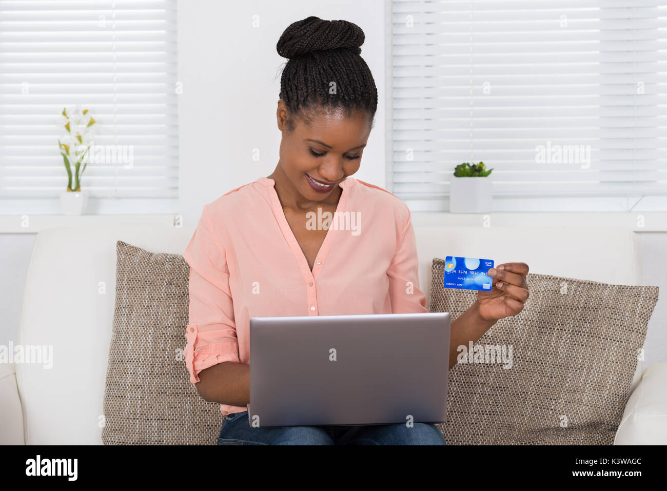 Happy African Woman Using Debit Card For Shopping Online On Laptop Stock Photo