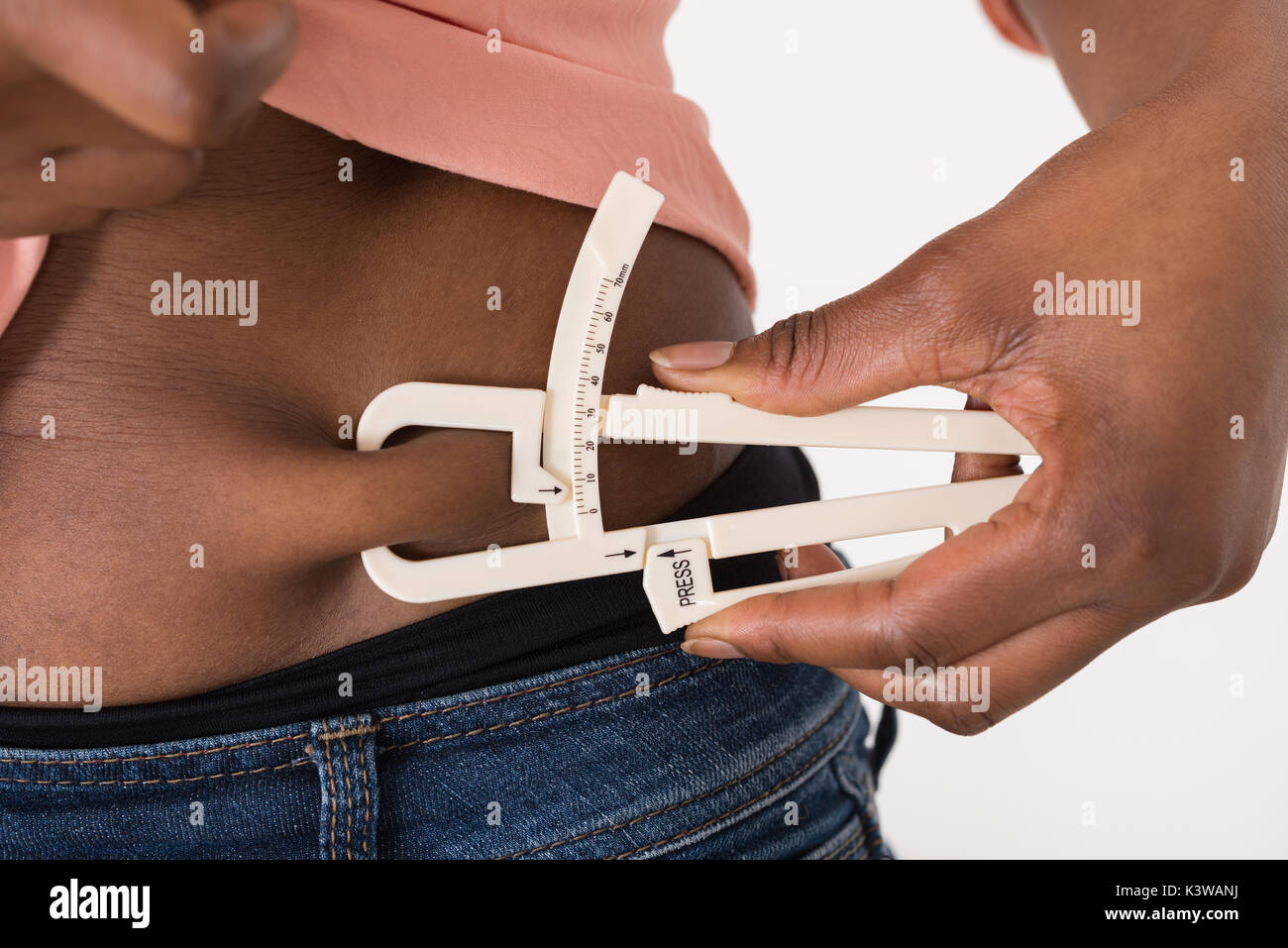 Close-up Of A Woman Measuring Body Fat Using Calipers Stock Photo