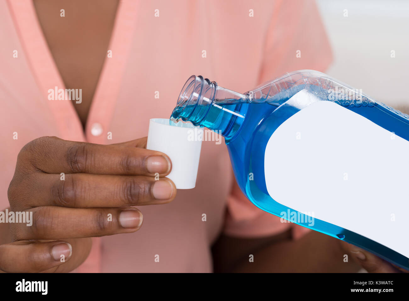 Closeup Of Person Pouring Mouthwash Into Bottle Cap Stock Photo Alamy
