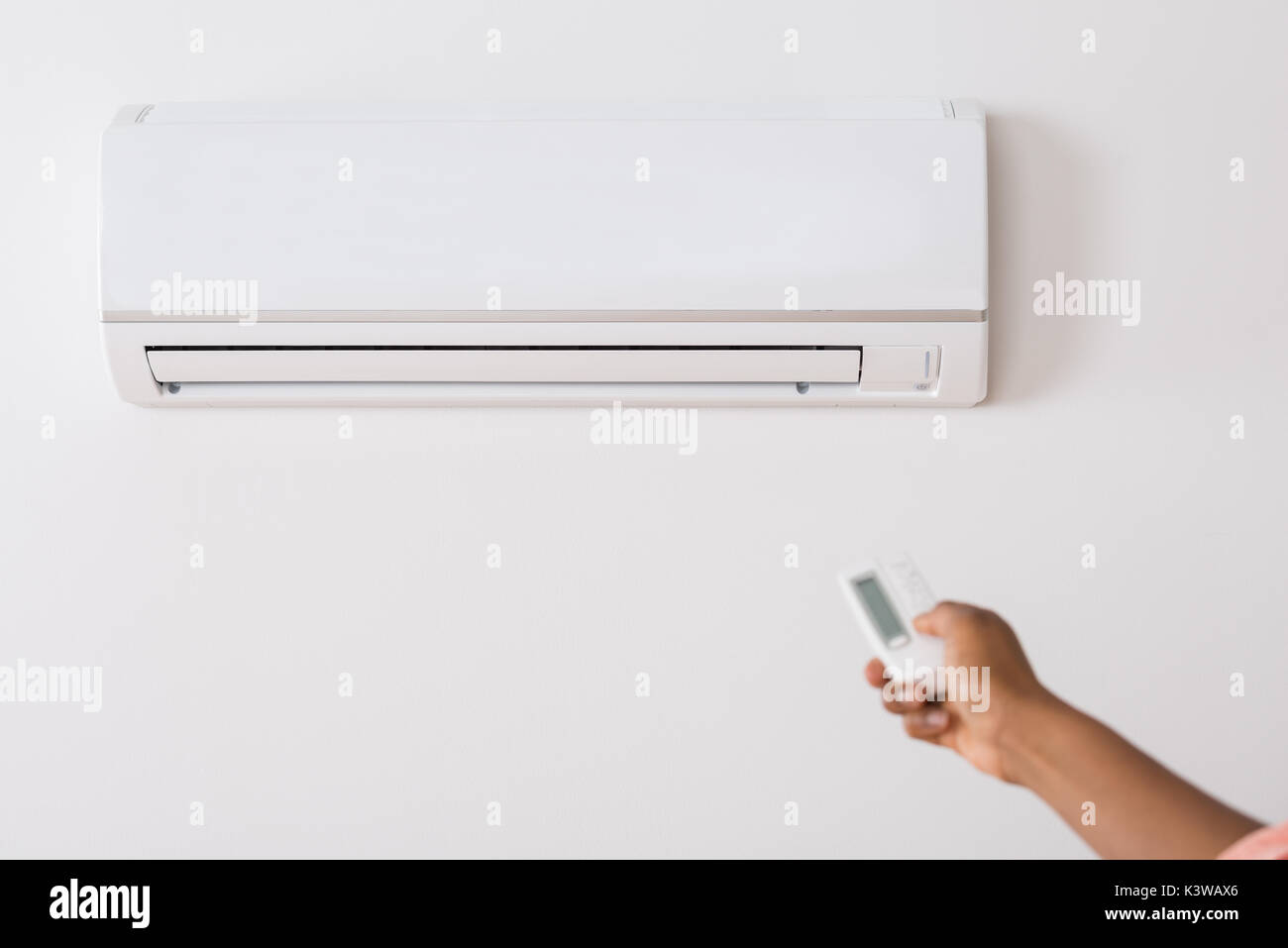 Close-up Of A Person's Hand Holding Remote To Operate Air Conditioner ...