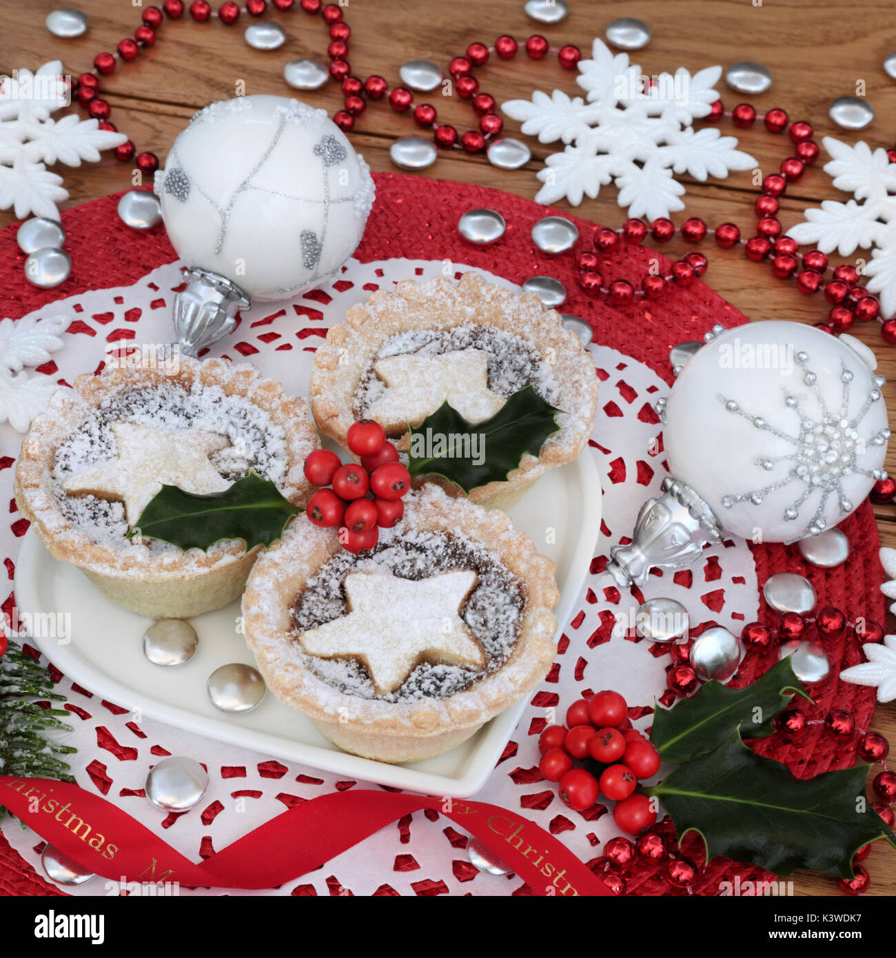 Traditional christmas mince pie tarts on a heart shaped plate with ...