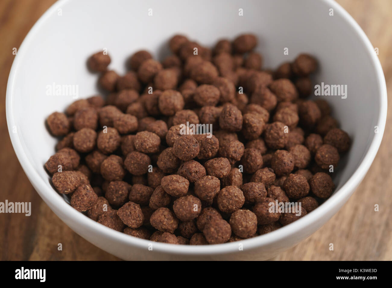 Star shaped honey coated cereal in a white bowl and wooden