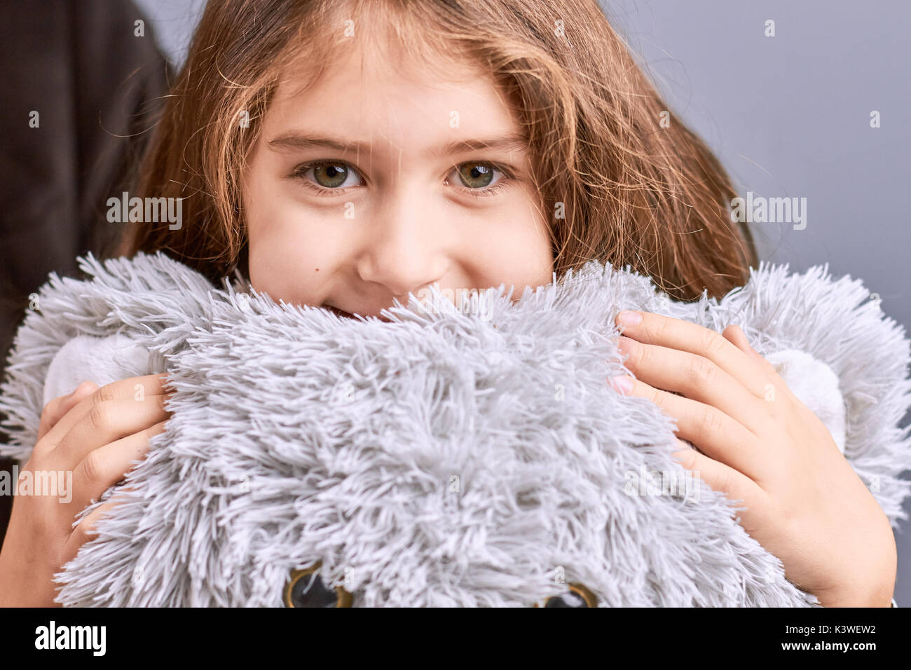 Portrait of little girl with teddy bear. Beautiful little girl hugging grey teddy bear. Portrait