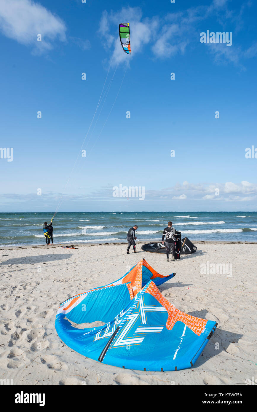 Kite surfer preparing at the beach and surfing on the sea at the Steinwarder beach at Heiligenhafen, Schleswig-Holstein, Germany Stock Photo